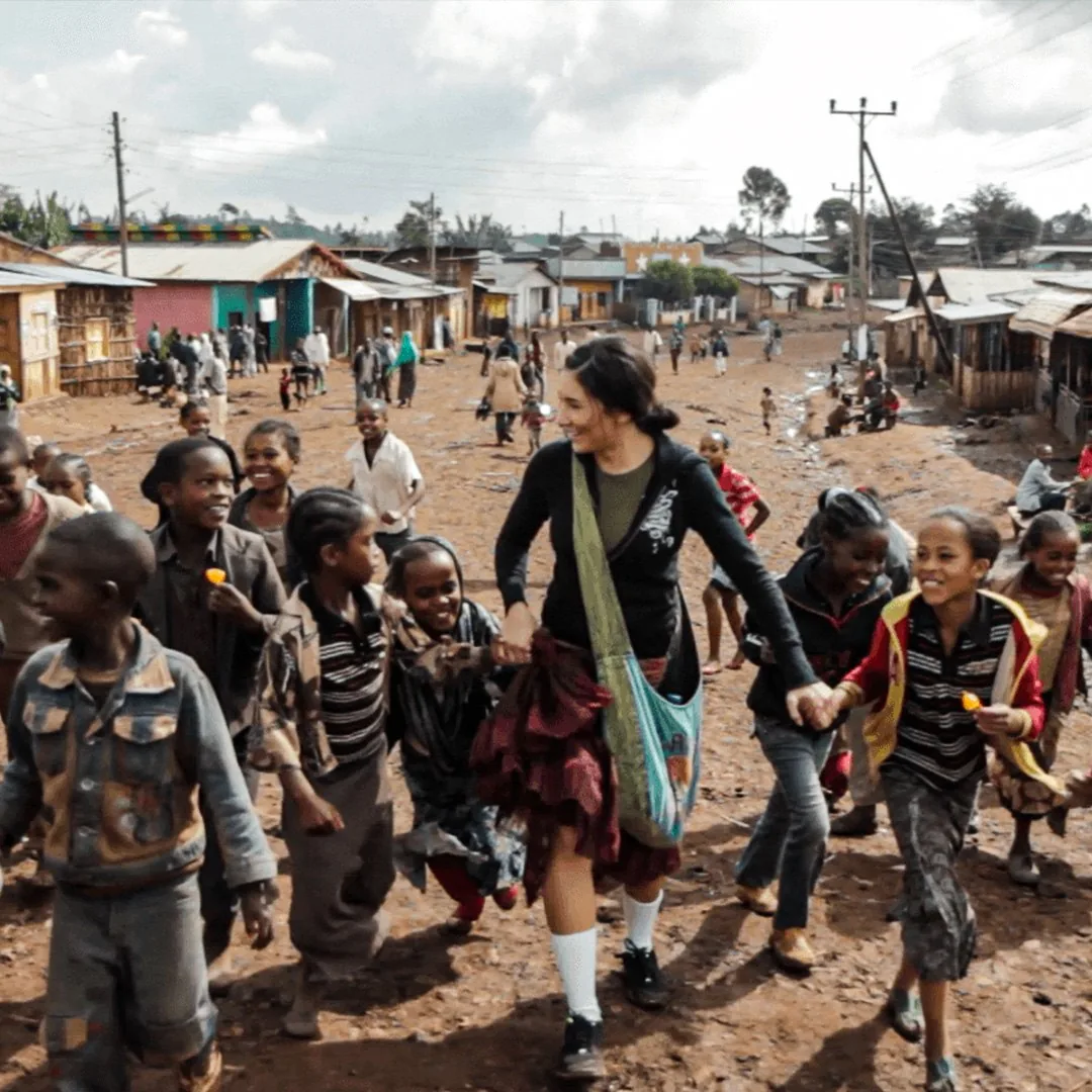 A young Mission One Eleven pioneer running hand-in-hand with children in Ethiopia