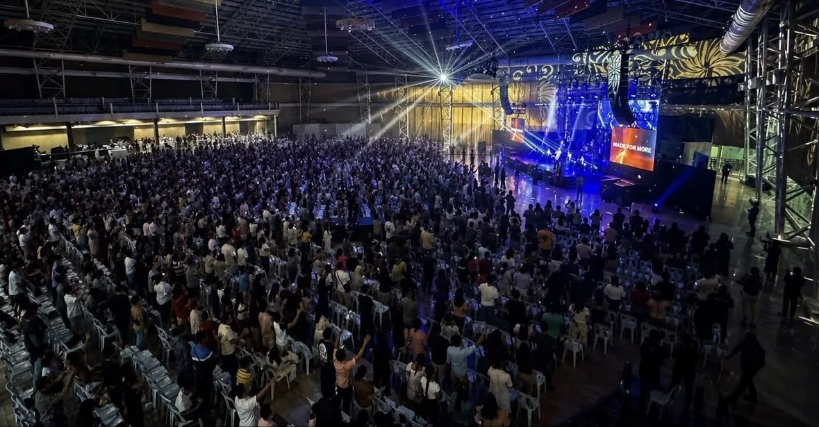 Wide view of the conference arena filled with attendees