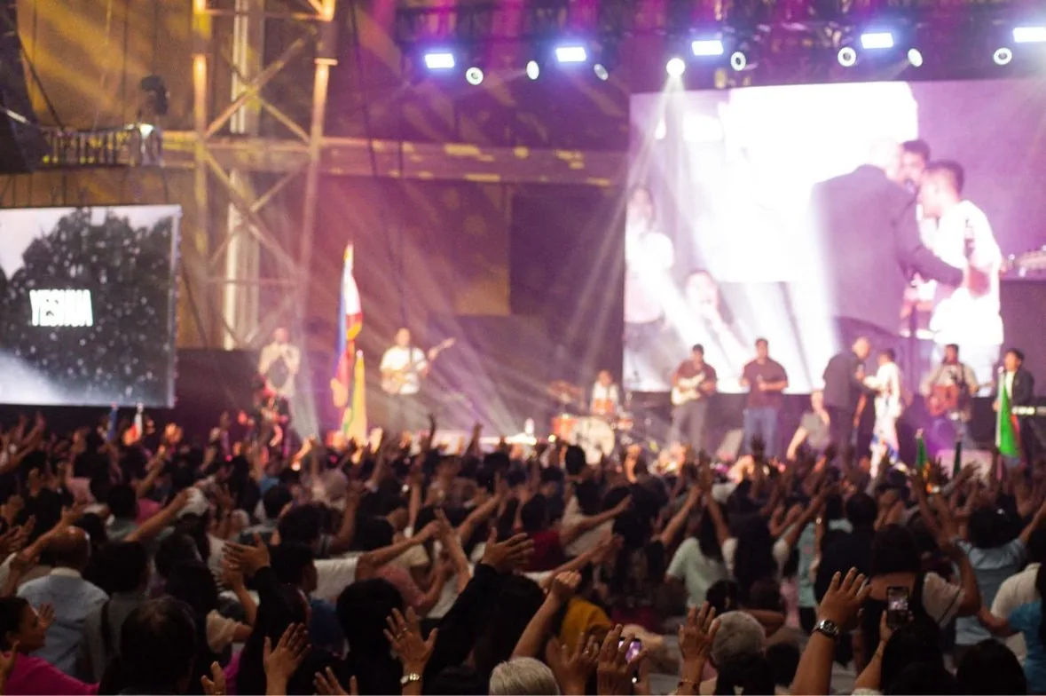 Congregation worshiping with hands raised